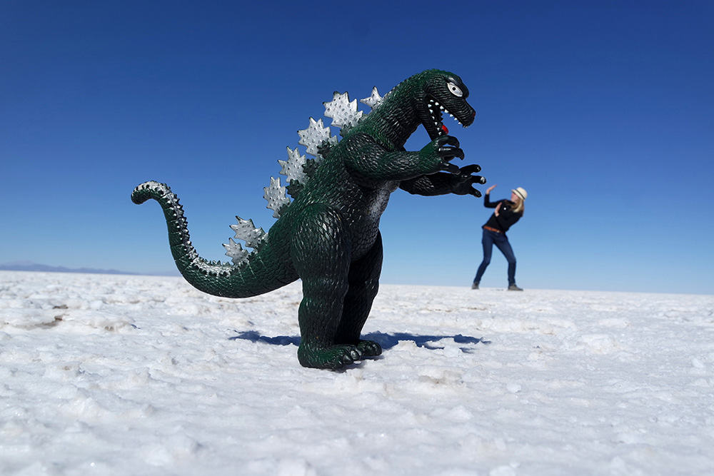 Ujunio druskos ežere (Bolivija) svarbiausia pramoga – įsiamžinti su žaisliniu dinozauru