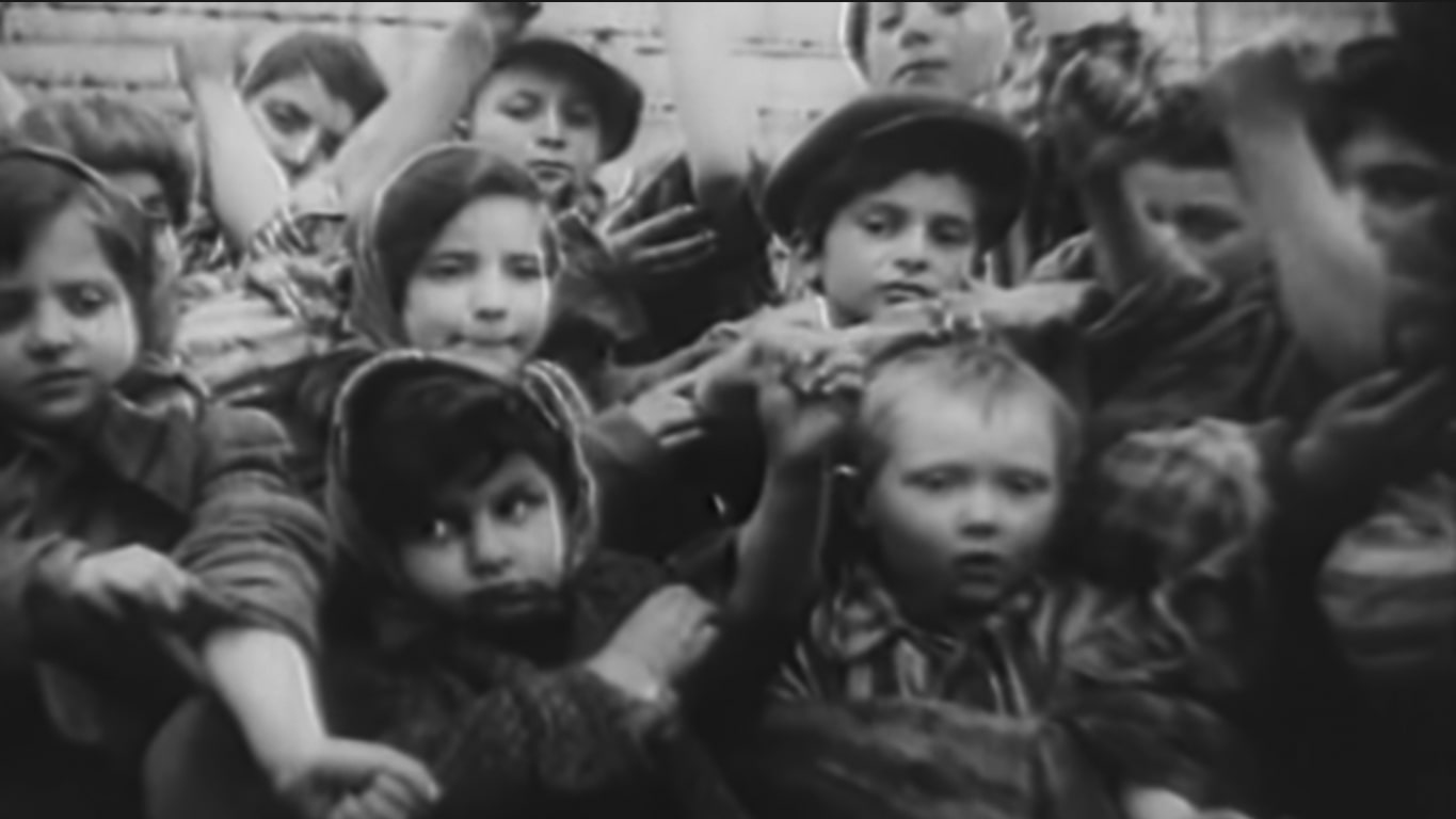1945 m. sausio 27 d. Aušvice vaikai savo ištatuiruotus numerius demonstruoja išvaduojančios Raudonosios armijos kino operatoriui